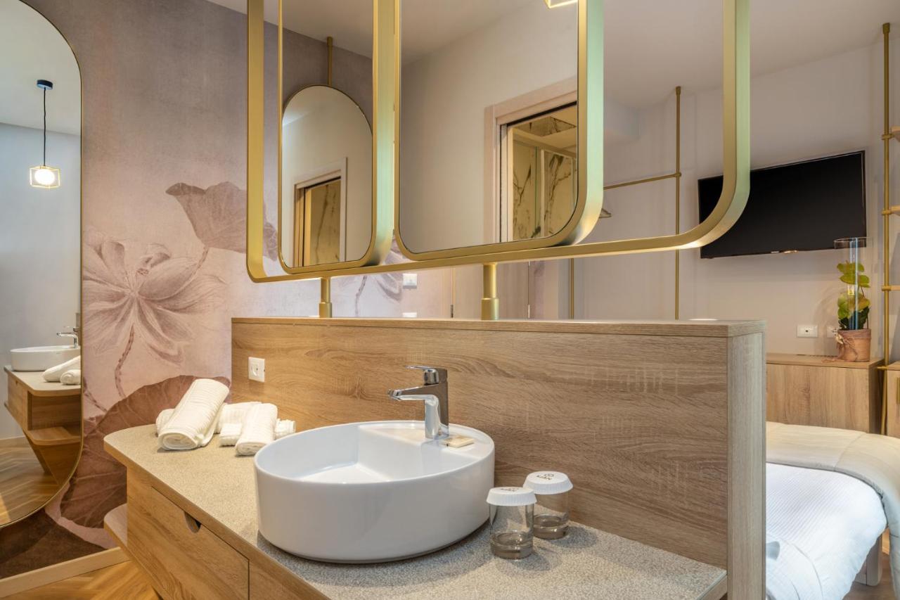 een badkamer met een wastafel en twee spiegels bij Salus Smart & Chic Hotel in Lido di Jesolo