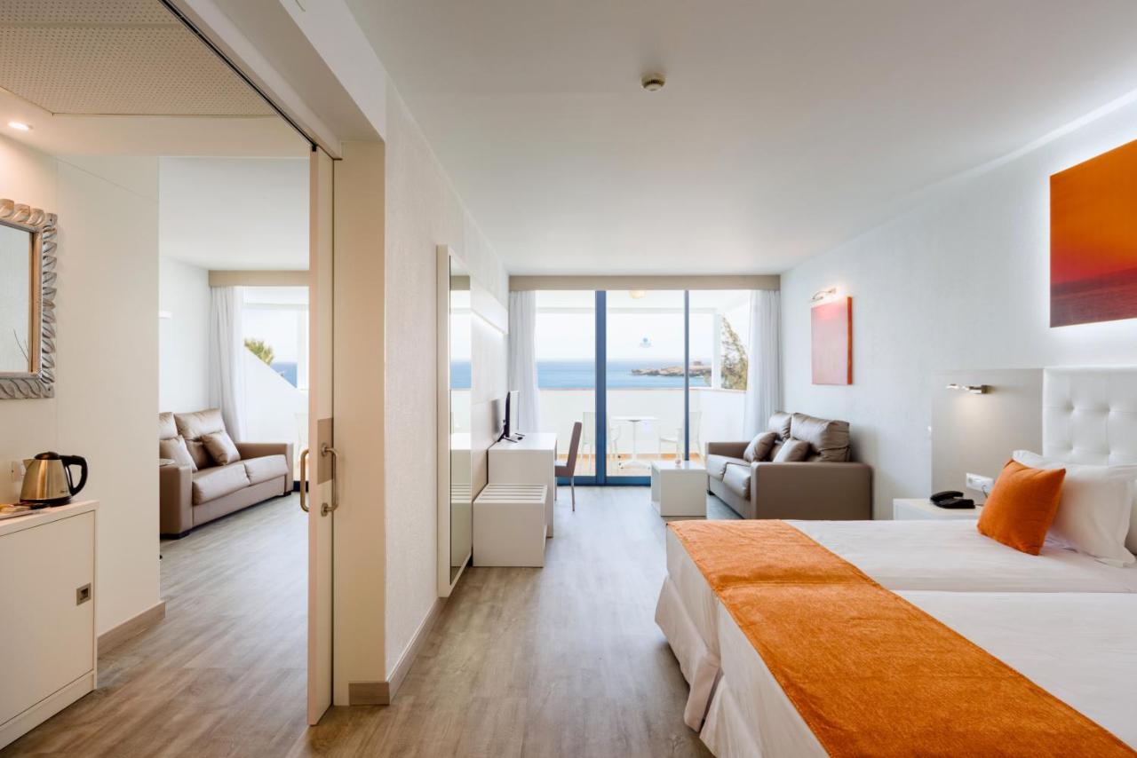 een hotelkamer met een bed en een woonkamer bij Sandos Papagayo in Playa Blanca