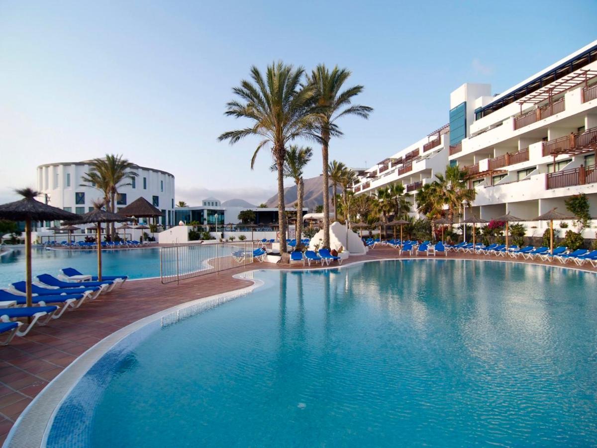 een groot zwembad naast een hotel bij Sandos Papagayo in Playa Blanca