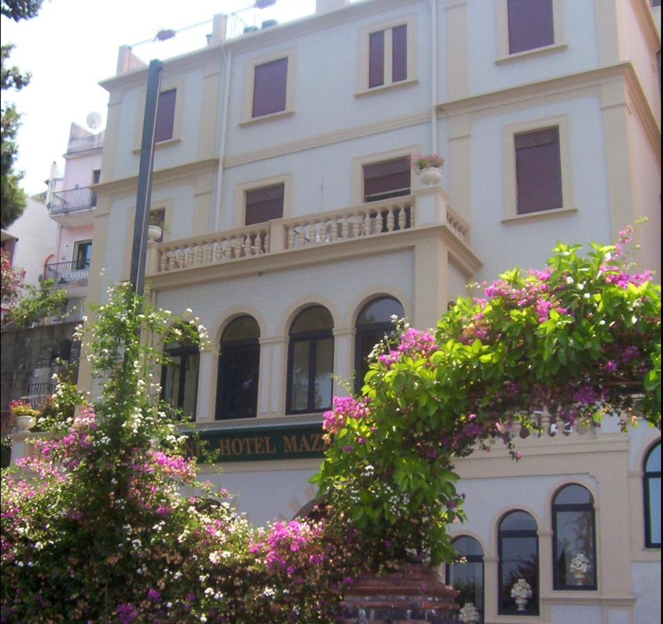een gebouw met roze bloemen ervoor bij Jonic Hotel Mazzarò in Taormina