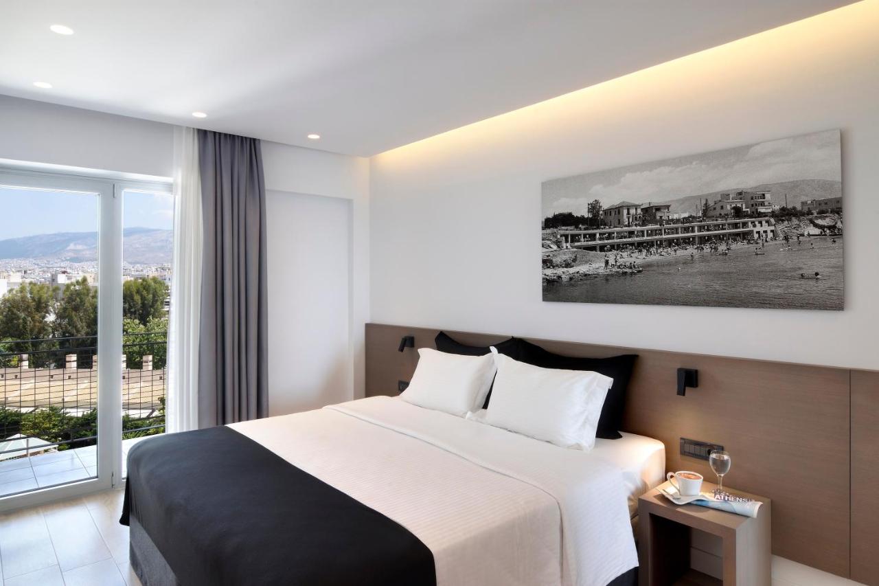 een hotelkamer met een bed en een groot raam bij Poseidon Athens Hotel in Athene