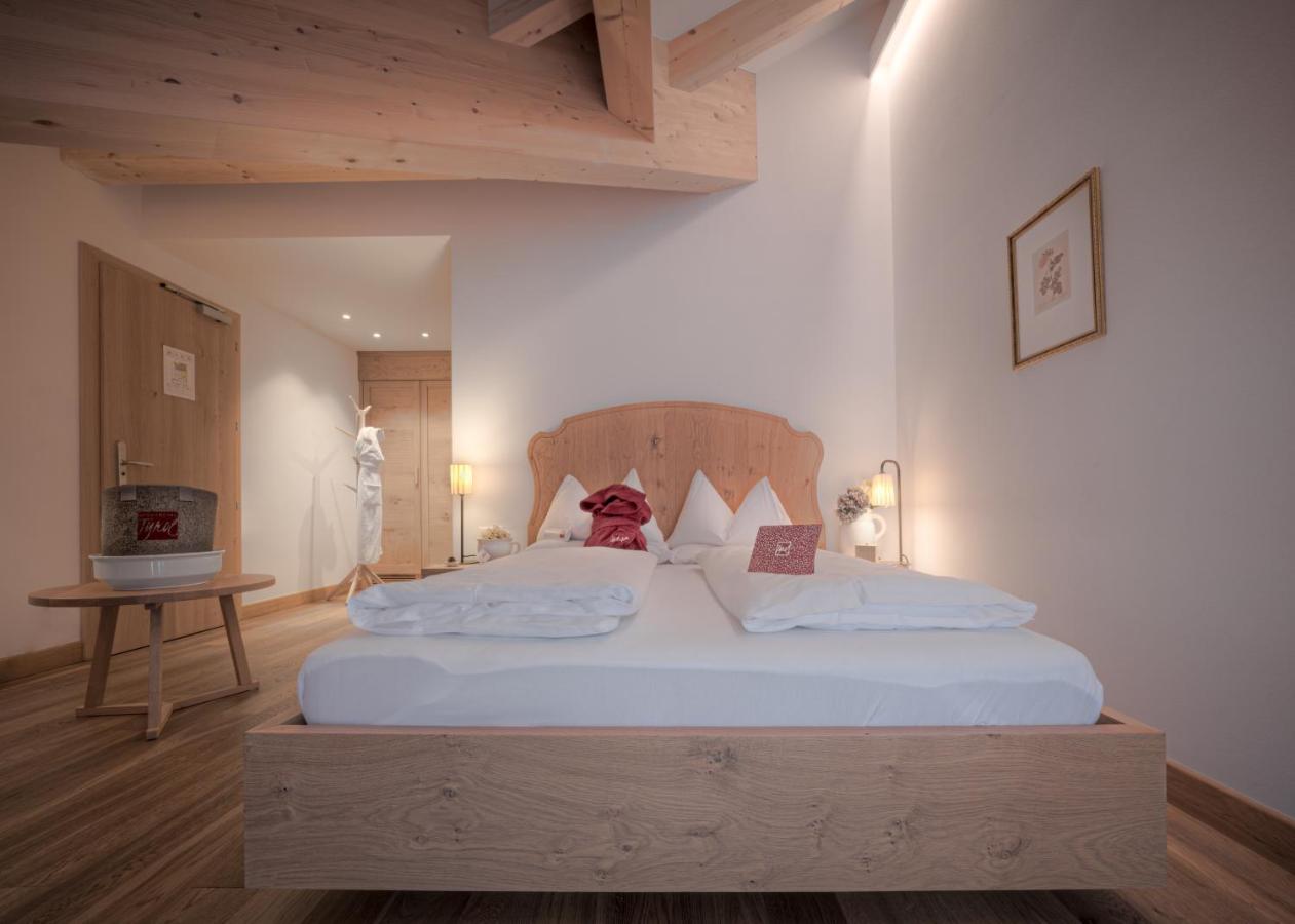 een slaapkamer met een groot wit bed met een houten hoofdeinde. bij Il Tyrol in San Candido +126 foto's