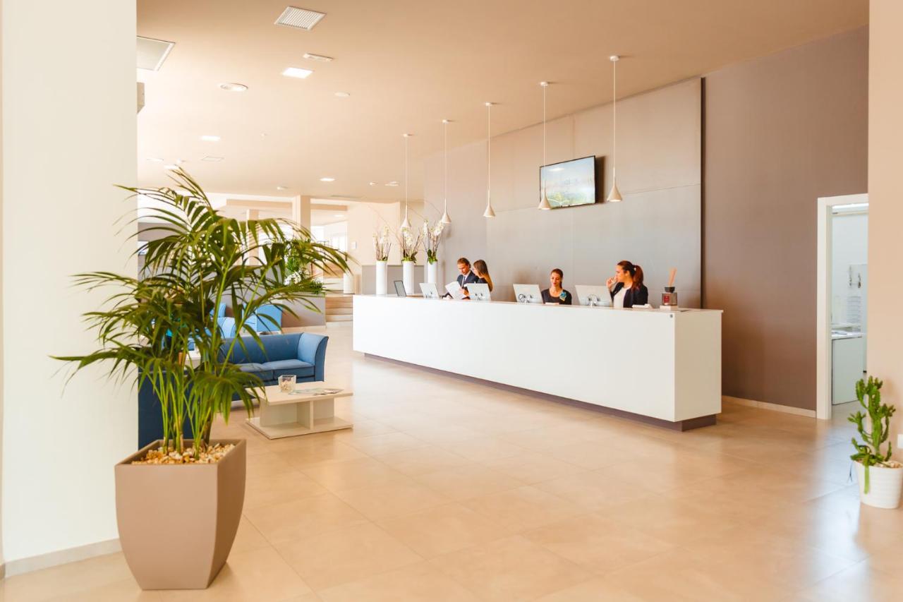 een lobby met mensen die aan een receptiebalie zitten bij Torre Cintola Greenblu Sea Emotions in Monopoli