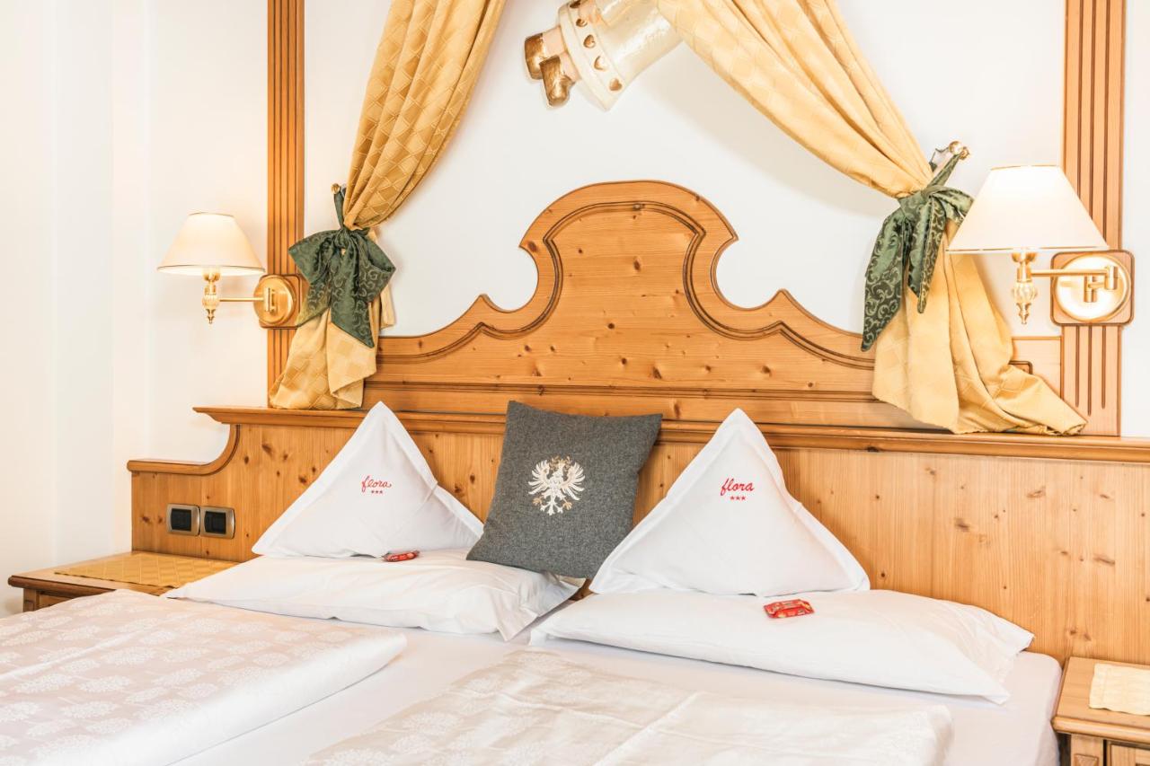 een bed met twee witte kussens erop bij Hotel Flora in Selva di Val Gardena