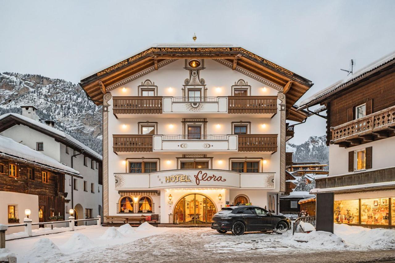 een zwarte auto geparkeerd voor een gebouw bij Hotel Flora in Selva di Val Gardena