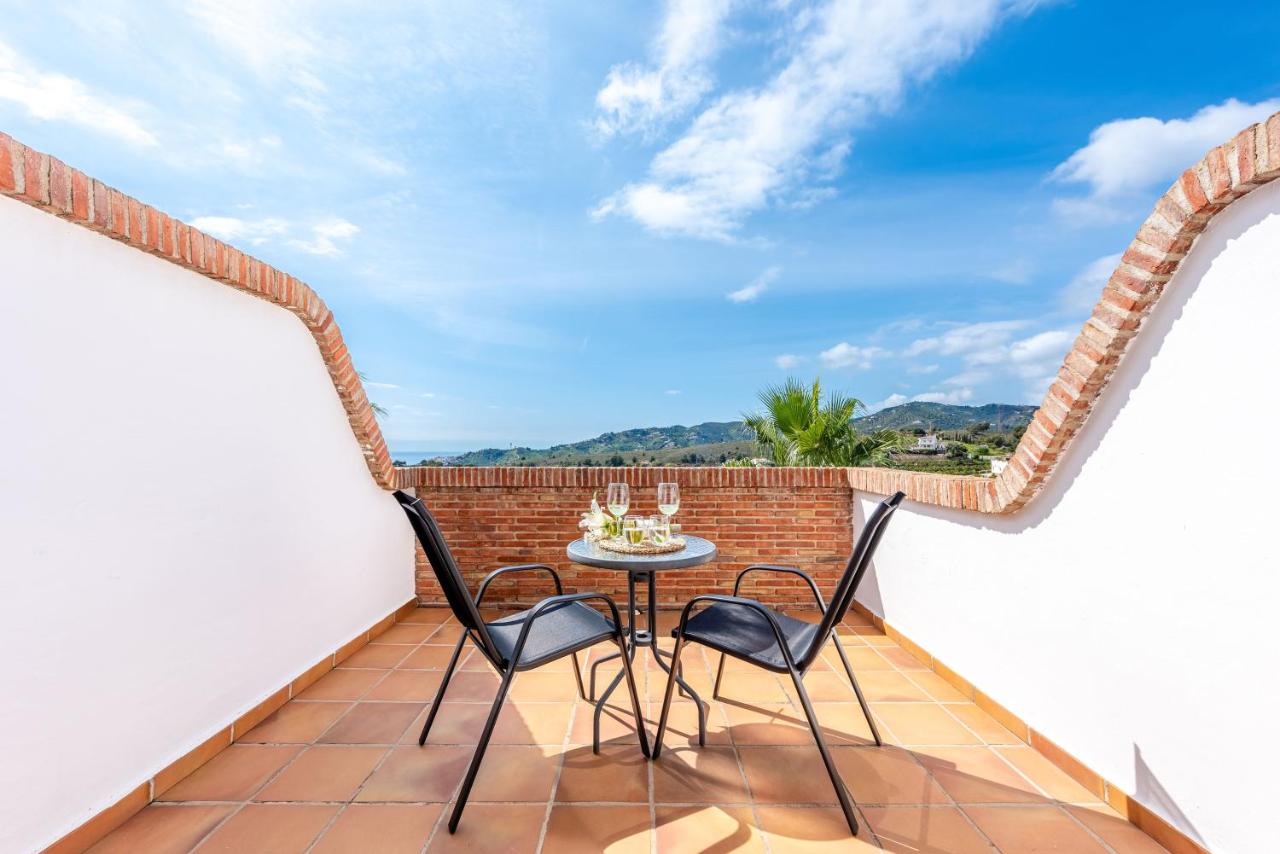 een terras met twee stoelen en een tafel op een balkon bij Hotel Rural Almazara in Frigiliana
