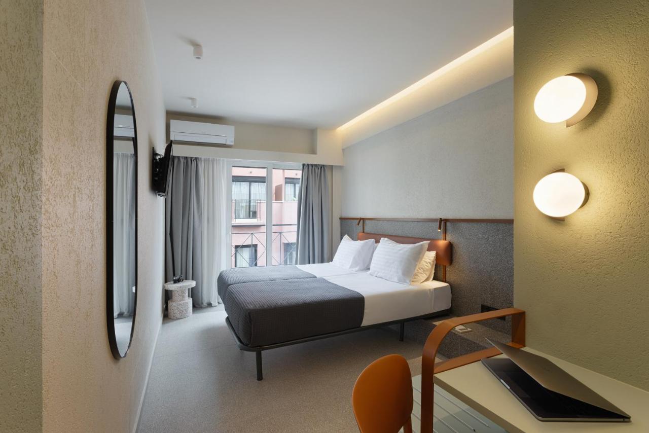 een hotelkamer met een bed en een spiegel bij Evripides Hotel in Athene