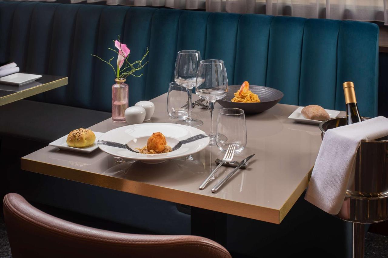een tafel met borden met eten en wijnglazen bij NH Firenze in Florence