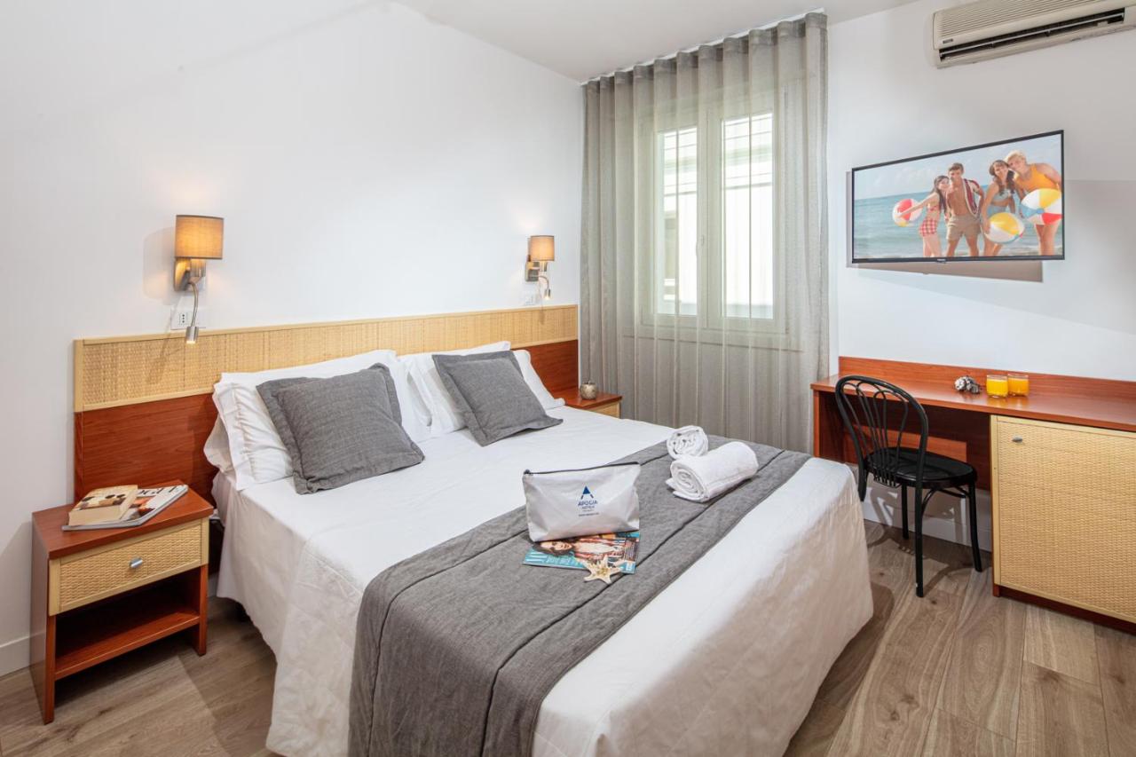 een hotelkamer met een bed en een bureau met een laptop erop. bij Hotel Villa d'Este in Grado