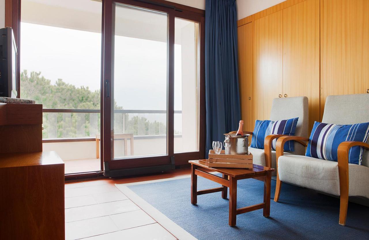 een woonkamer met een bank en een tafel bij Almadraba Park Hotel in Roses