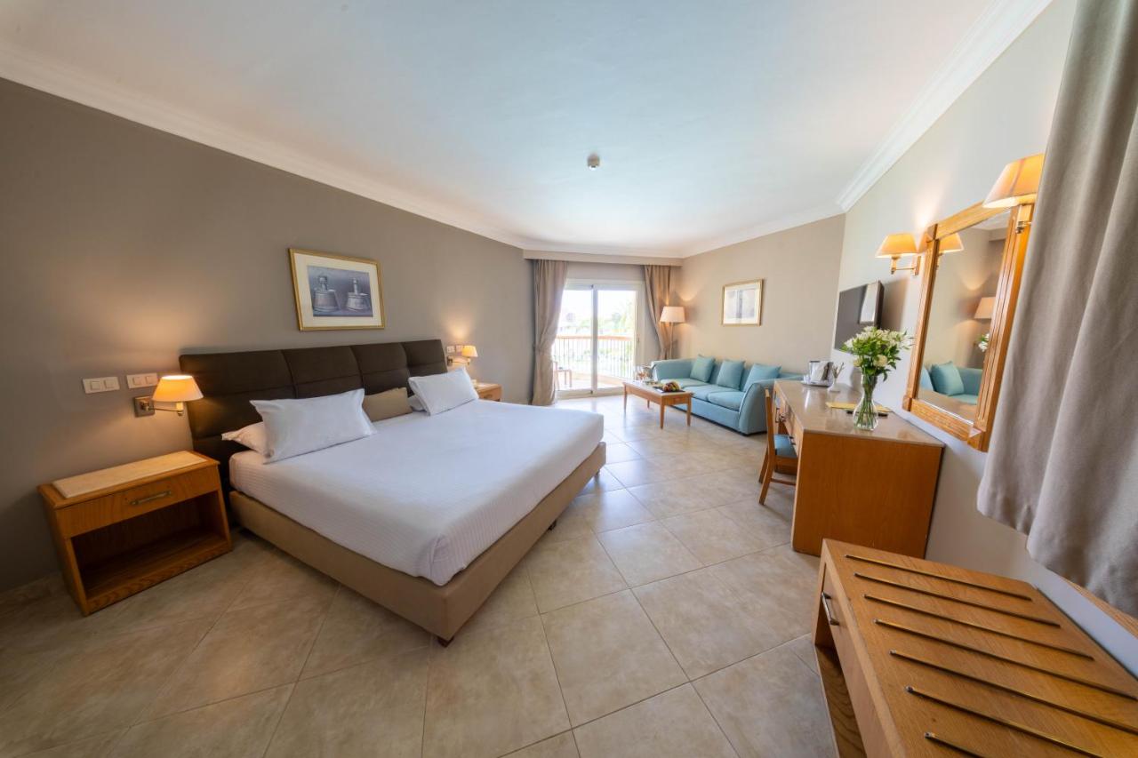 een slaapkamer met een bed en een woonkamer bij Aurora Oriental Resort Sharm El Sheikh in Sharm El Sheikh