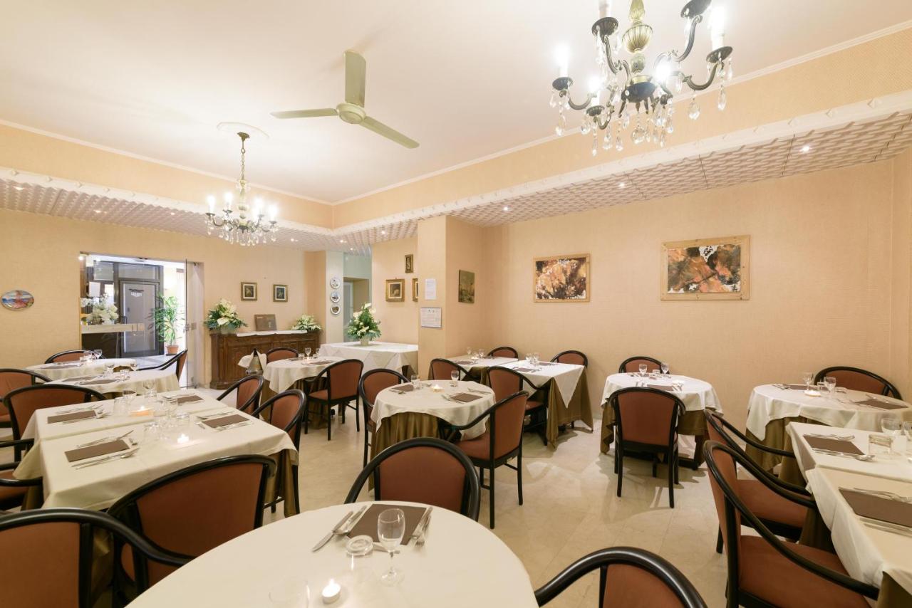 een eetkamer met witte tafels en stoelen bij Hotel Morchio Mhotelsgroup in Diano Marina