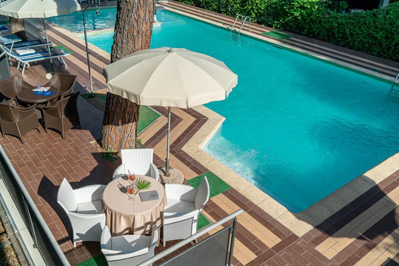 Een bovenaanzicht van een tafel en parasol naast een zwembad. bij Hotel Martini in Lignano Sabbiadoro
