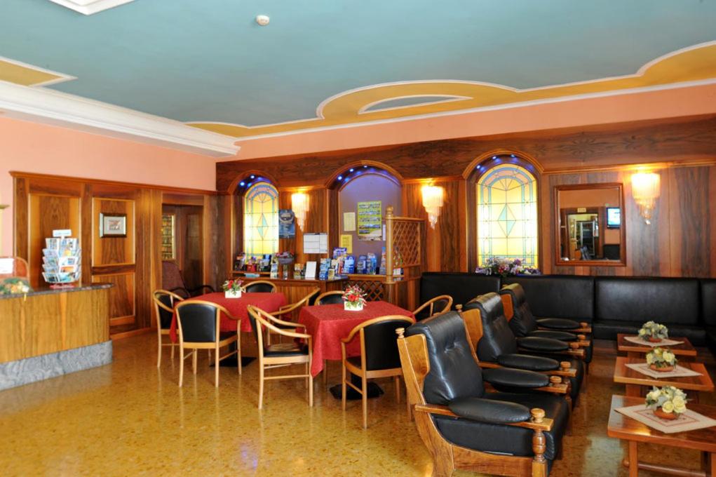 een restaurant met tafels en stoelen en een bar bij Park Hotel Jolanda in San Zeno di Montagna