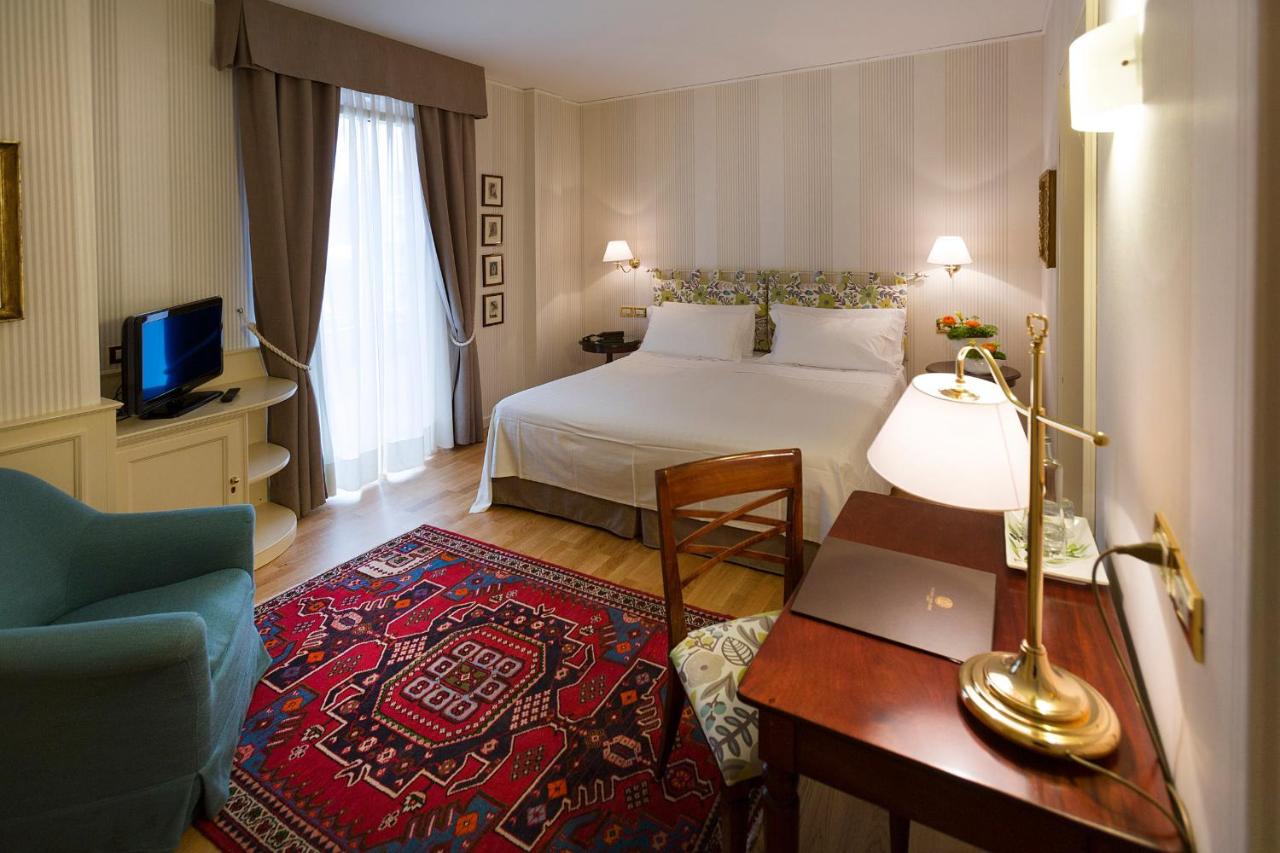 een hotelkamer met een bed en een bureau bij Regina Adelaide Hotel & SPA in Garda