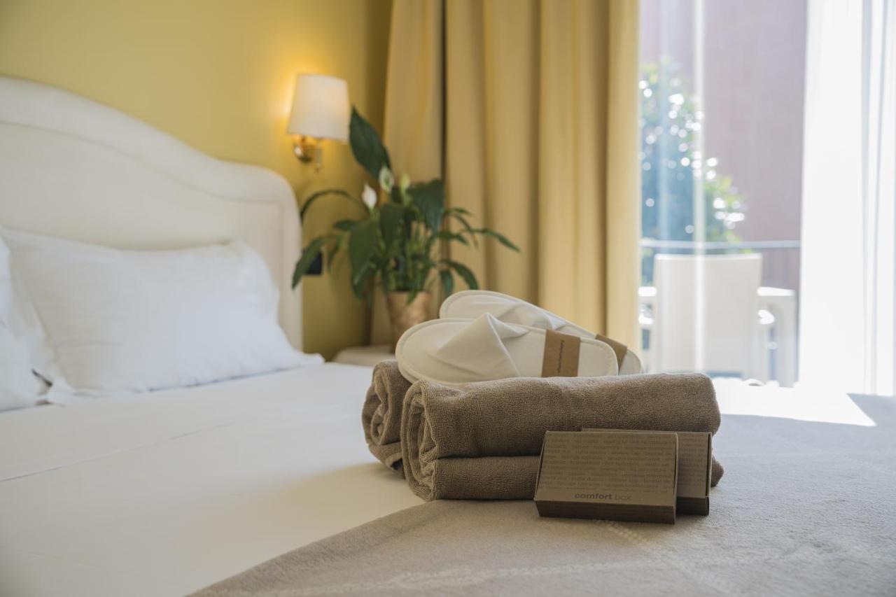 een hotelkamer met een bed en een stapel handdoeken bij Admiral Hotel Villa Erme in Desenzano del Garda