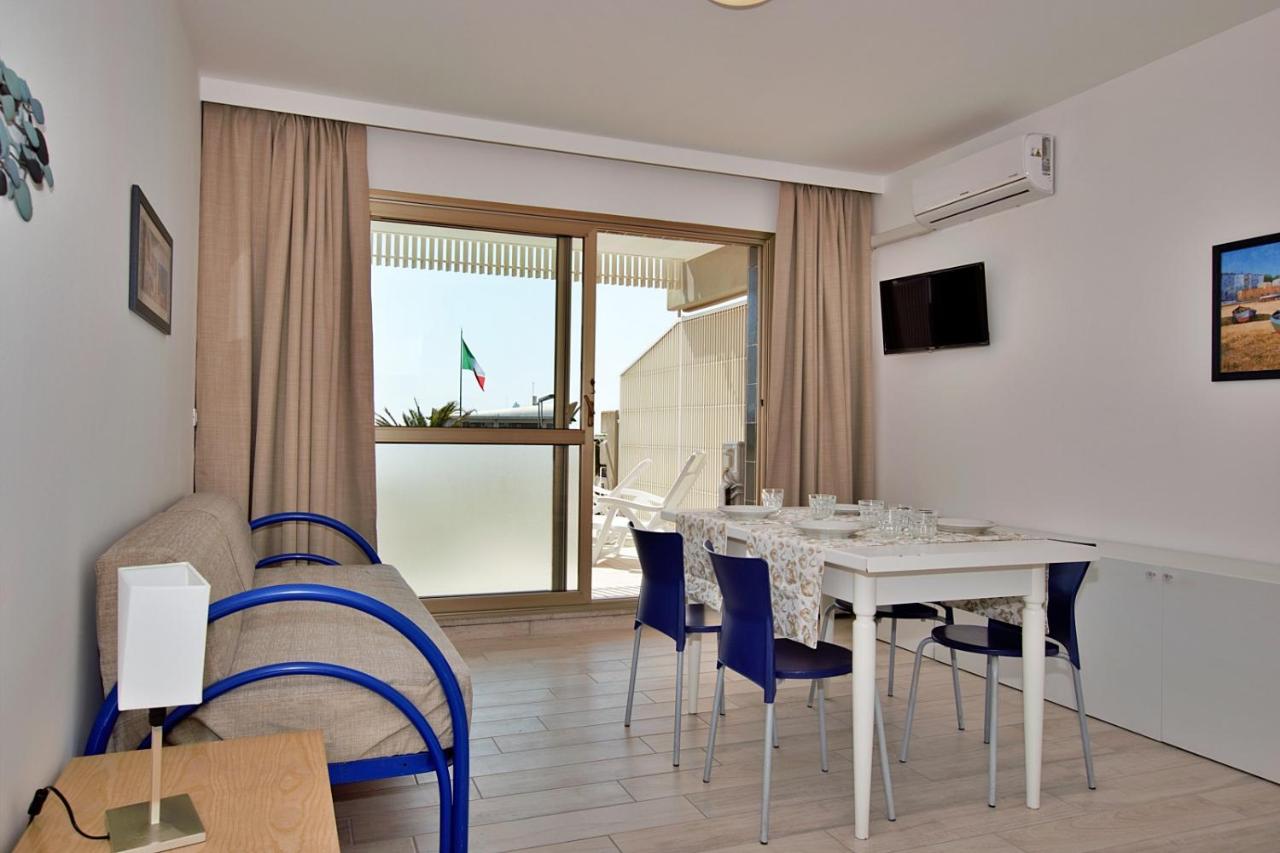 een eetkamer met een witte tafel en blauwe stoelen bij Residence Spiaggia in Lignano Sabbiadoro +33 foto's