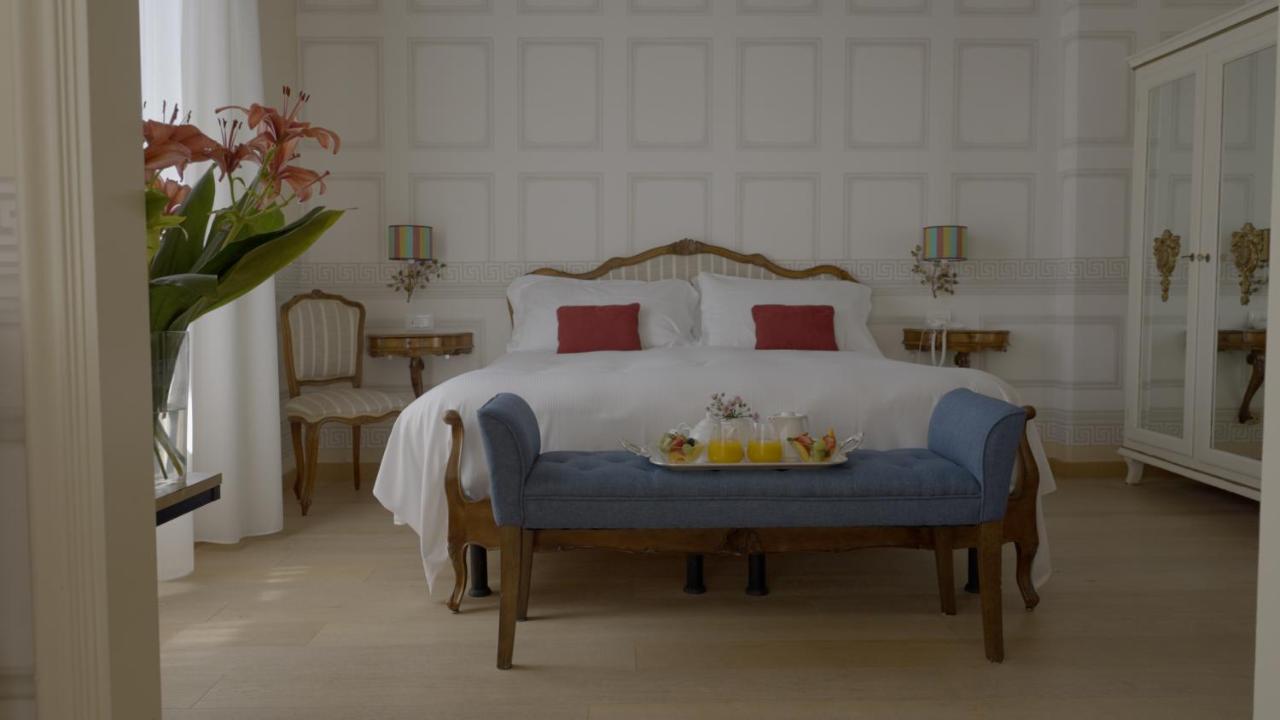 een slaapkamer met een bed waarop een dienblad met fruit staat bij Palace Hotel in Viareggio