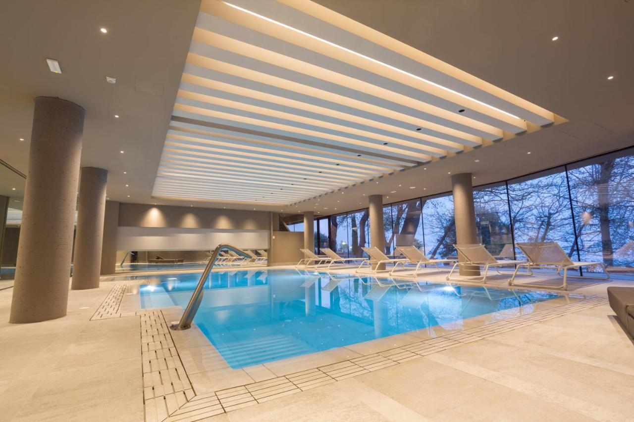 een groot zwembad in een hotel met ligstoelen bij Airone Wellness Hotel in Zafferana Etnea