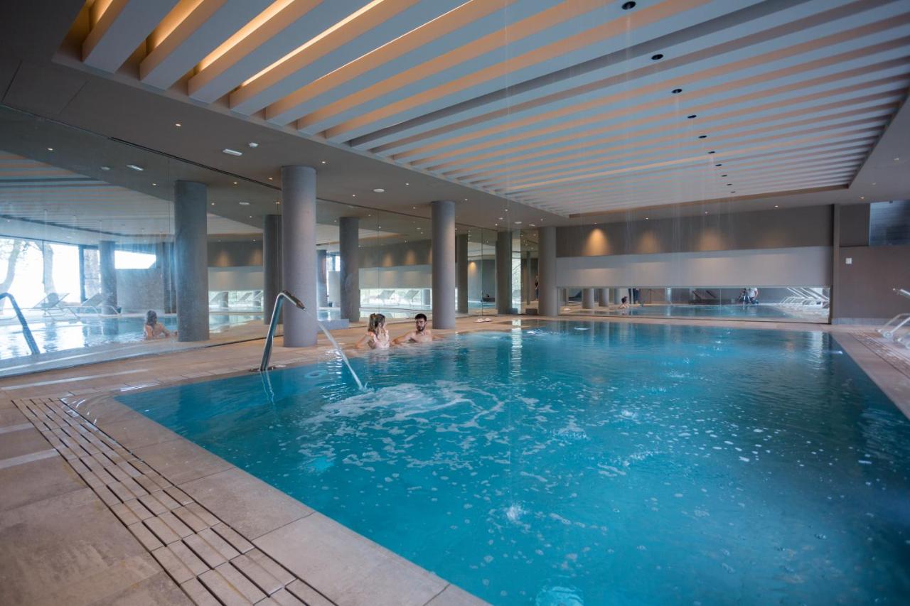 twee personen in een zwembad in een gebouw bij Airone Wellness Hotel in Zafferana Etnea