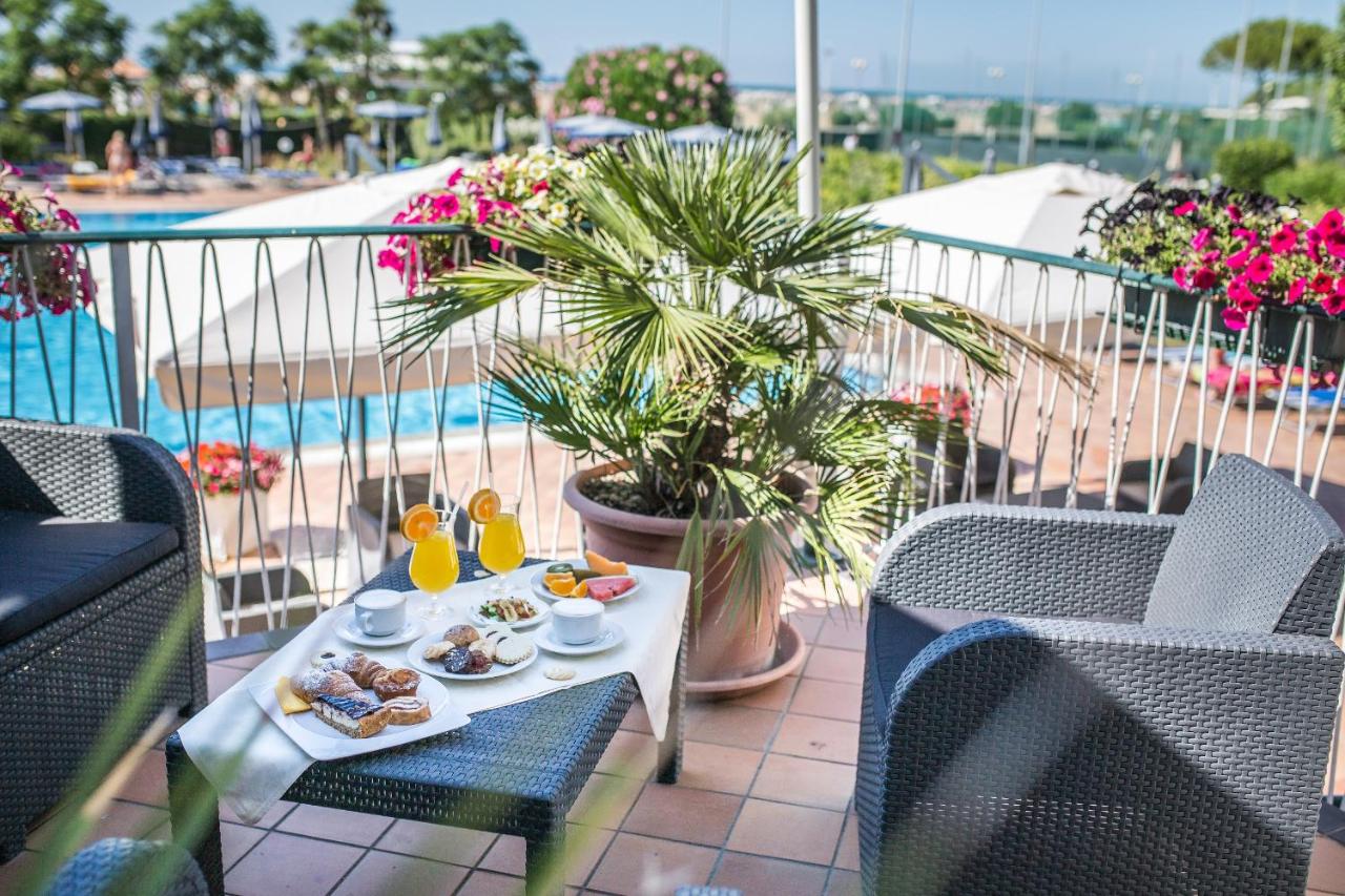 een dienblad met eten op een tafel op een balkon bij Hotel Royal in Bibione