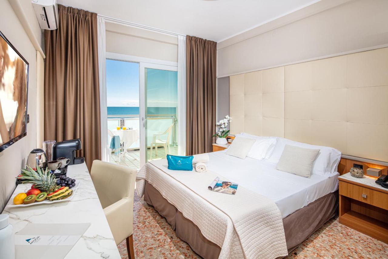 een hotelkamer met een bed en uitzicht op de oceaan bij Hotel Royal in Bibione +83 foto's