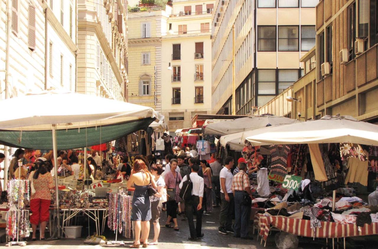 een menigte mensen die rondlopen op een markt in een stad bij Hotel Corona in Rome
