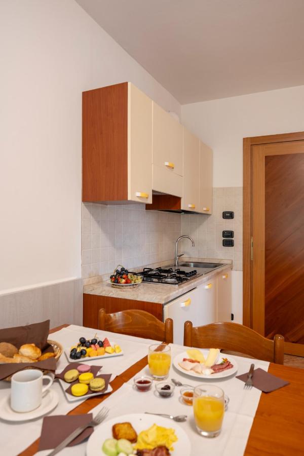 een keuken met een tafel waarop borden met eten staan bij Olimpia Hotel & Aparthotel in Bibione