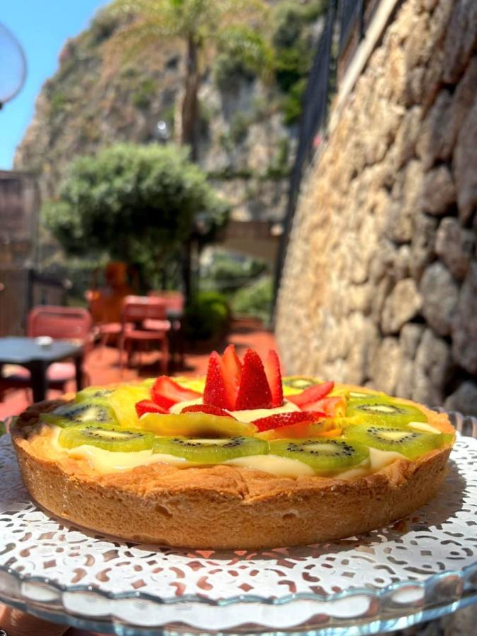een taart met aardbeien op een bord op een tafel bij Hotel Corallo in Taormina