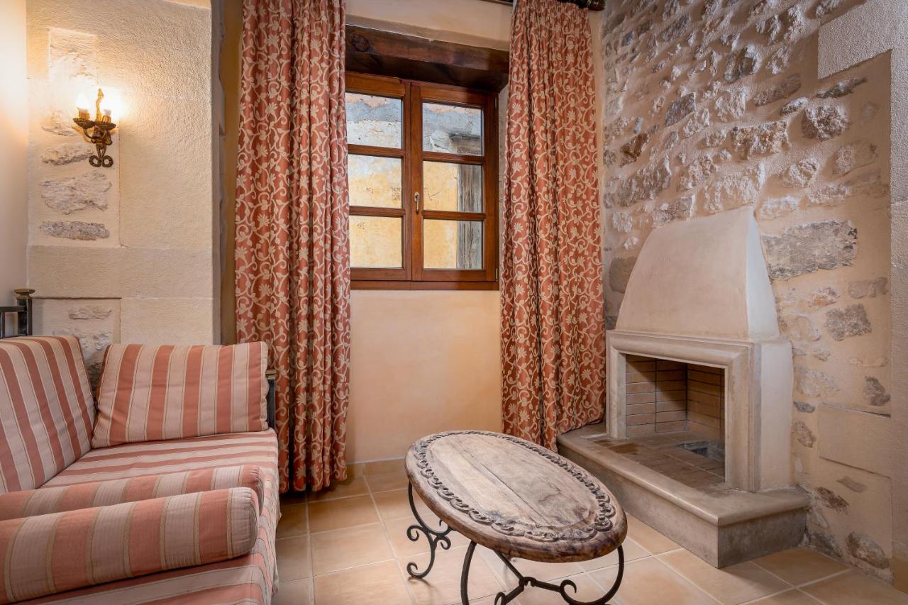 een woonkamer met een bank en een open haard bij Palazzino Di Corina in Rethimnon