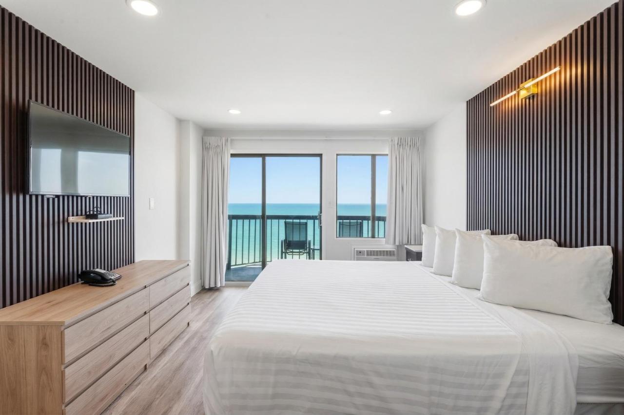 een slaapkamer met een groot bed en een groot raam bij Grande Beach Resort in Myrtle Beach