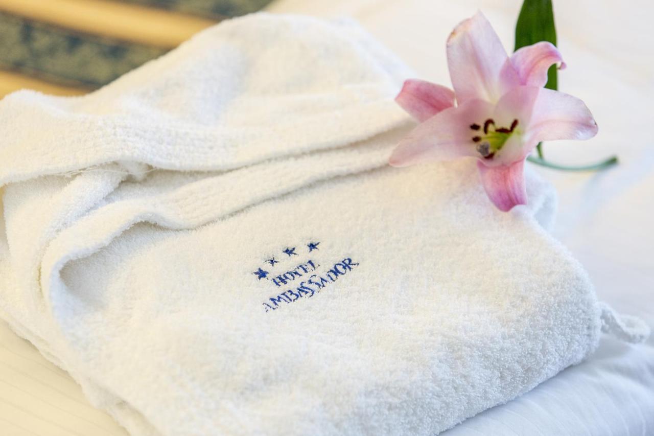 een witte handdoek met een roze bloem erop bij Hotel Ambassador in Tortoreto Lido