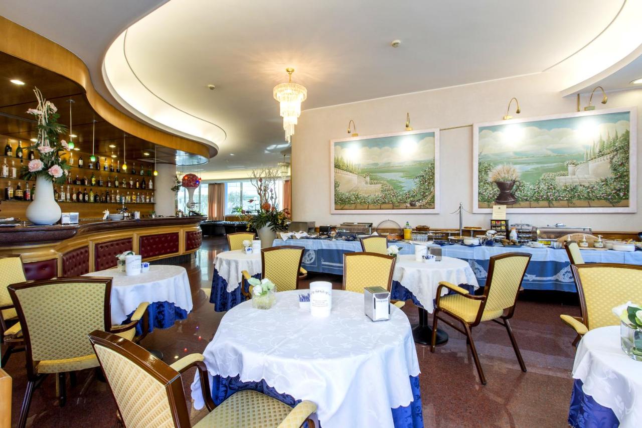een eetkamer met witte tafels en stoelen bij Hotel Ambassador in Tortoreto Lido