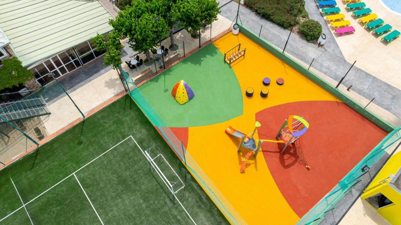 Een bovenaanzicht van een speelveld met een speeltuin. bij Medplaya Aparthotel Sant Eloi in Tossa de Mar