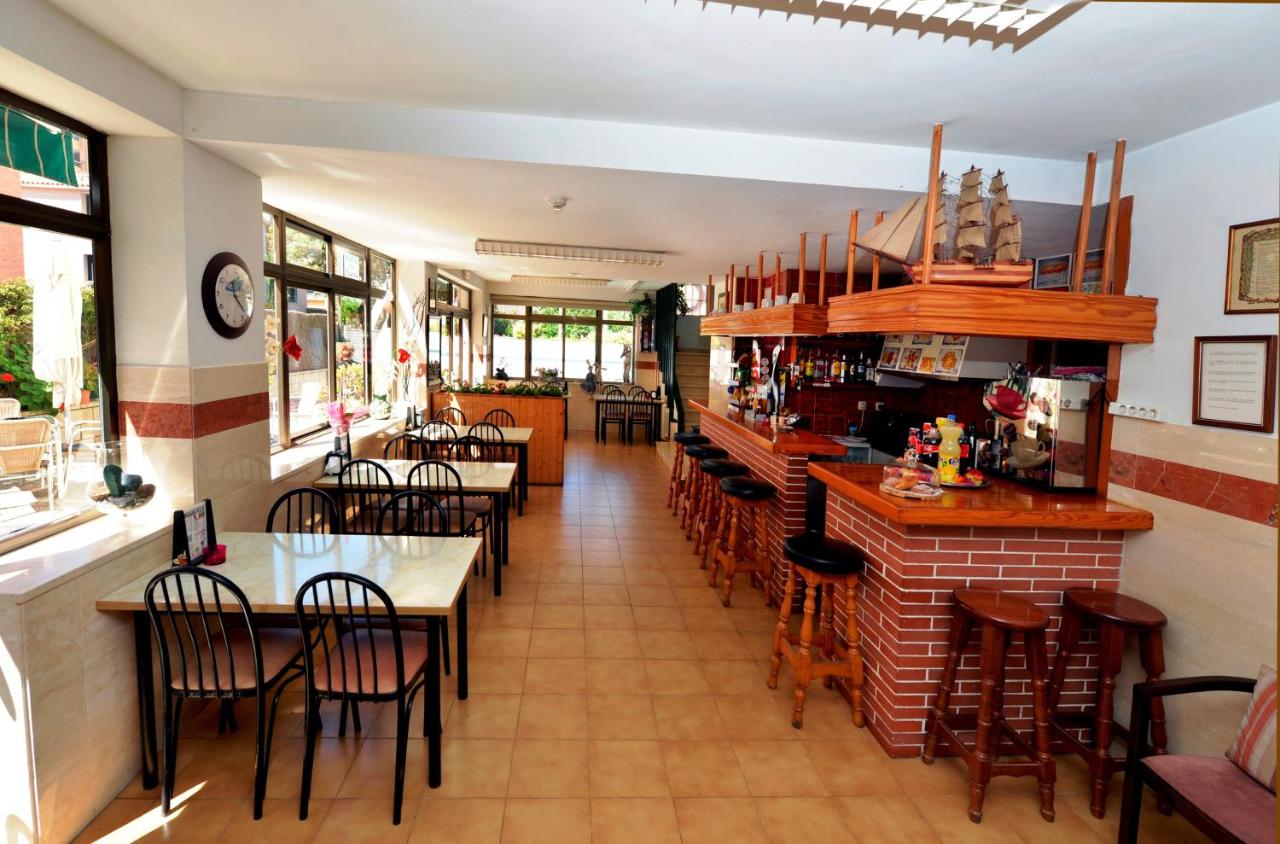 een restaurant met tafels en stoelen en een bar bij Hostal Magnolia in Lloret de Mar +28 foto's