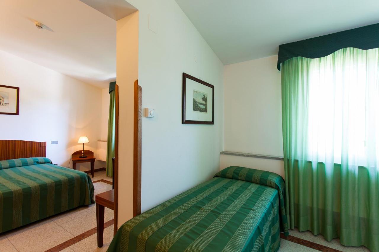 een hotelkamer met twee bedden en een raam bij Hotel Villa d'Amato in Palermo