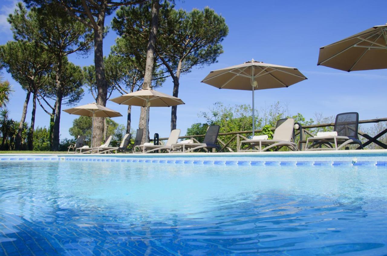 een zwembad met ligstoelen en parasols bij Oasi Olimpia Relais in SantʼAgata sui Due Golfi