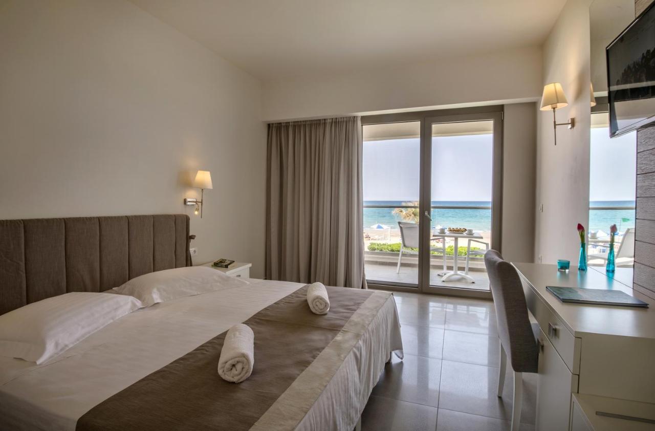 een slaapkamer met een bed en uitzicht op de oceaan bij Iperion Beach Hotel in Rethimnon +117 foto's