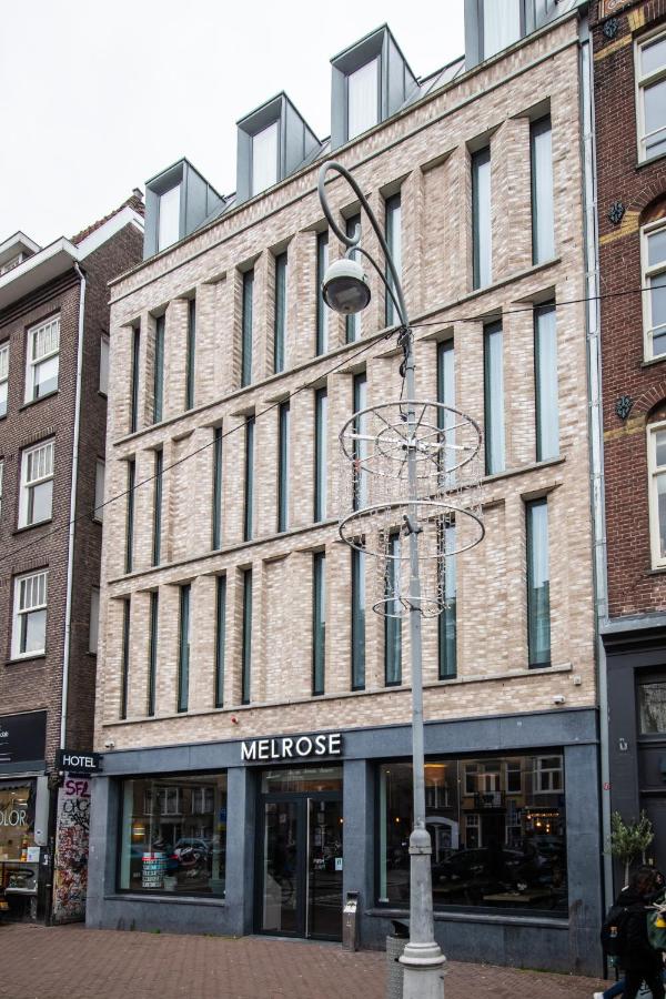 een straatlantaarn voor een groot bakstenen gebouw bij Melrose Hotel in Amsterdam