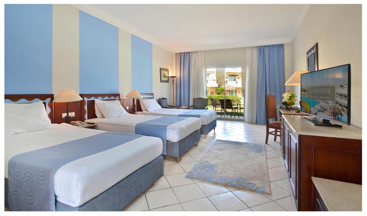 een hotelkamer met twee bedden en een televisie bij Concorde El Salam Sharm El Sheikh Sport Hotel in Sharm El Sheikh