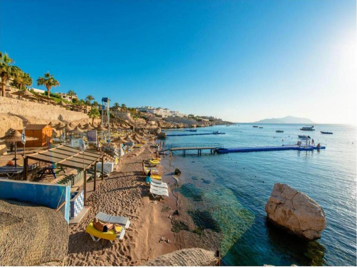 een strand met parasols en stoelen en het water bij Concorde El Salam Sharm El Sheikh Sport Hotel in Sharm El Sheikh