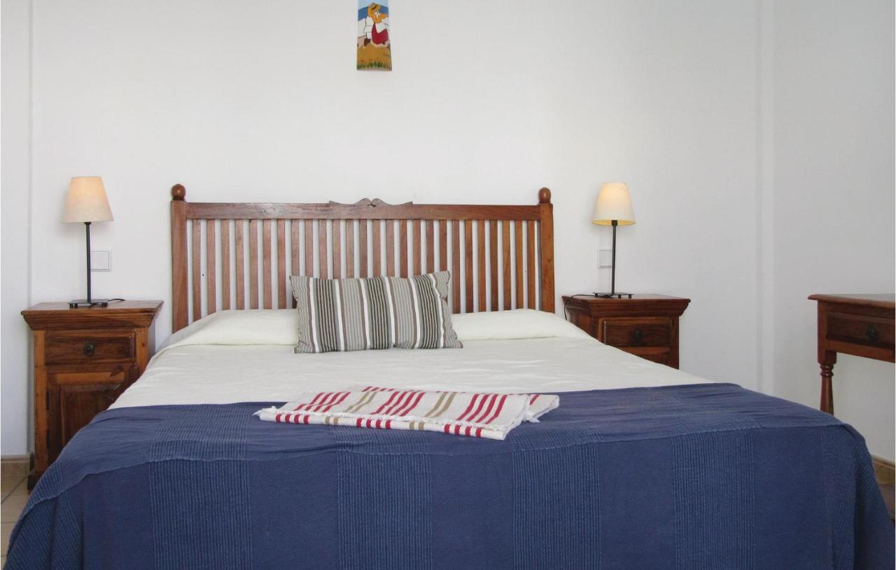 een bed met een blauwe deken en twee nachtkastjes bij Villas Del Mar in Puerto Calero