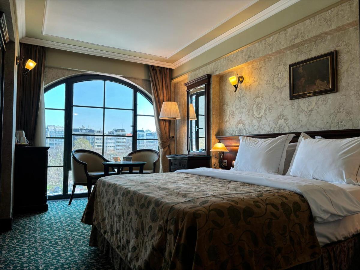 een hotelkamer met een bed en een groot raam bij Germir Palas Hotel - Special Class in Istanbul