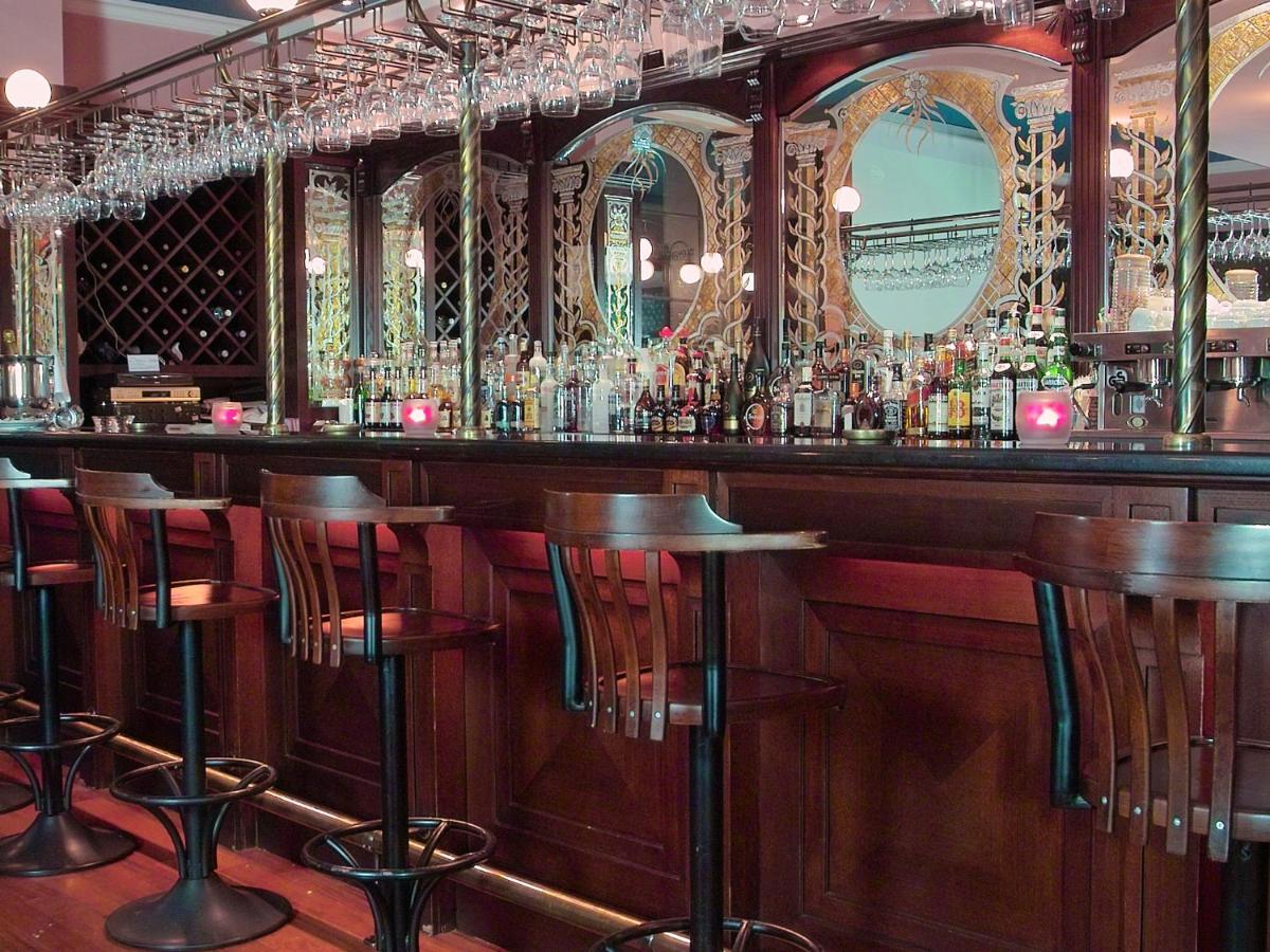 een bar met barkrukken in een kamer met spiegels bij Germir Palas Hotel - Special Class in Istanbul