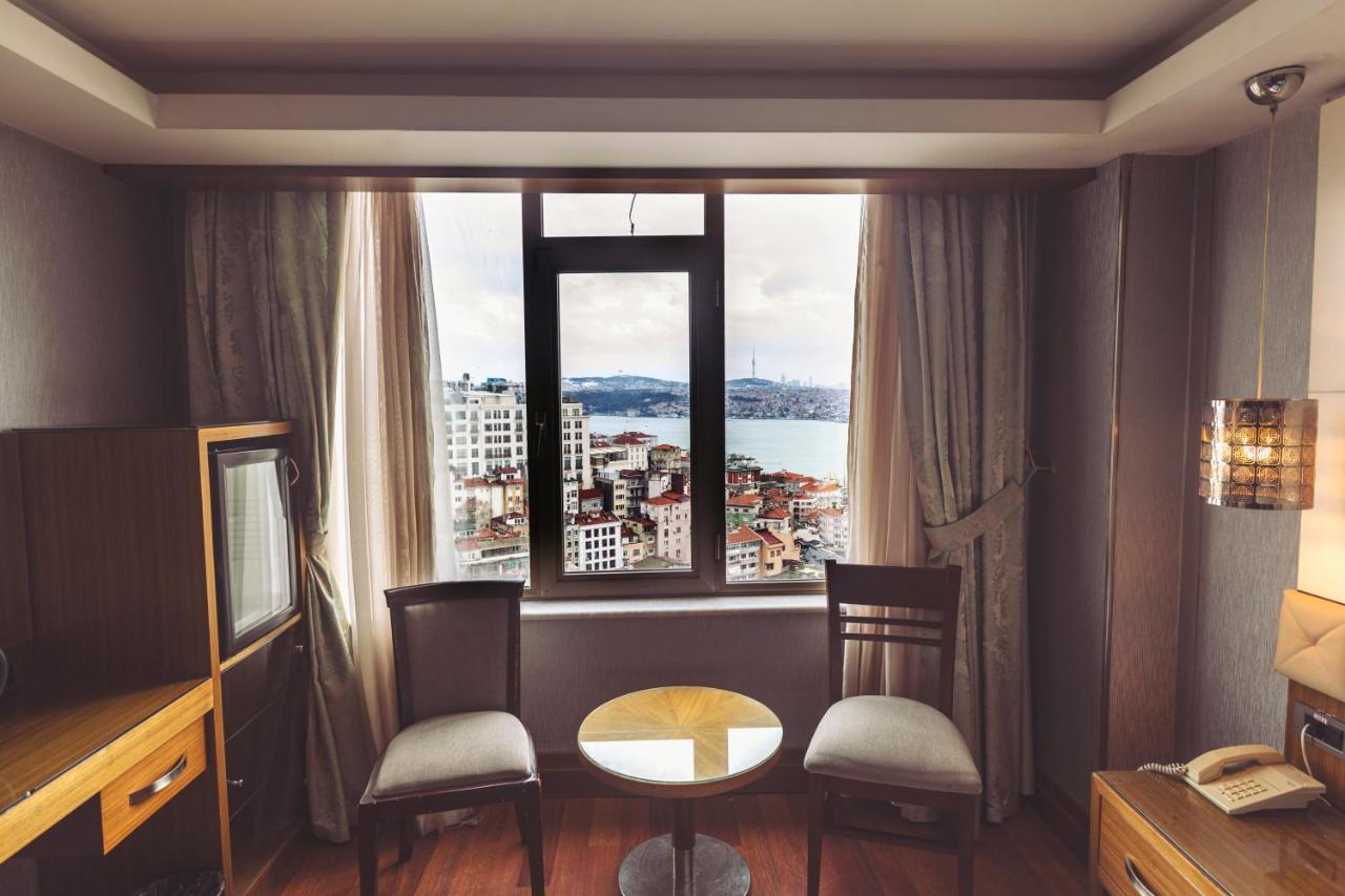 een kamer met een tafel en stoelen en een groot raam bij Style Star Hotel Cihangir in Istanbul
