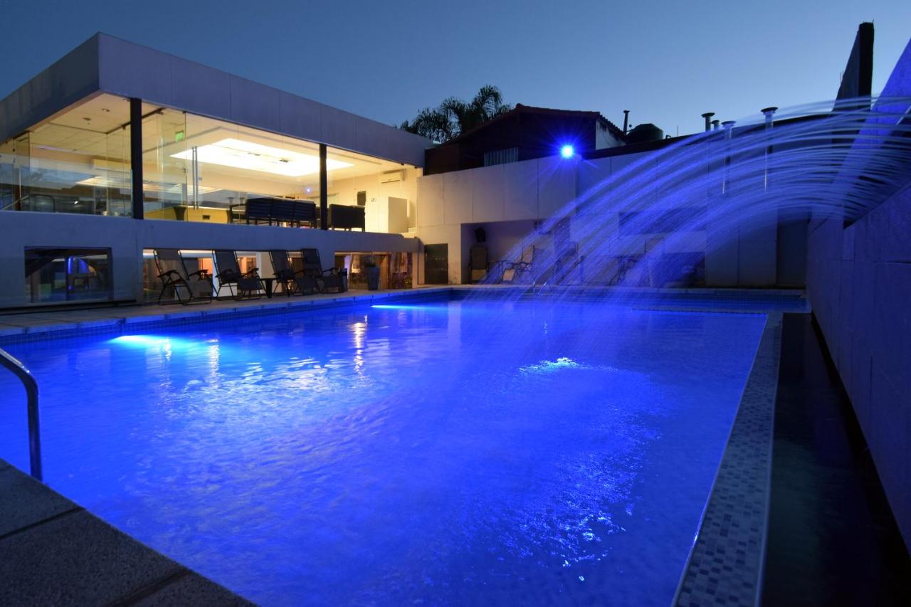 een zwembad met een waterfontein voor een gebouw bij Piazza Hotel in Villa Carlos Paz