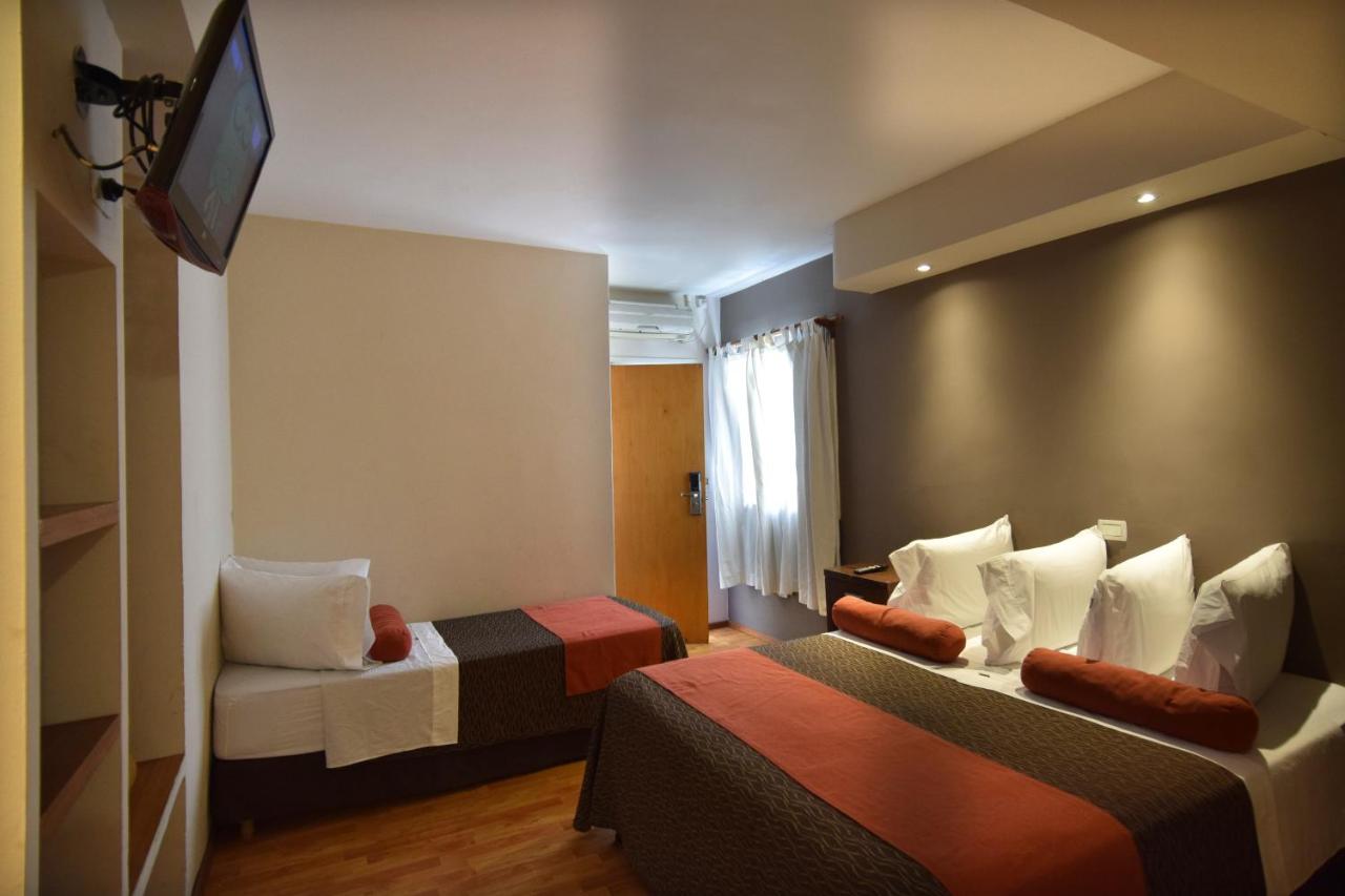 een hotelkamer met twee bedden en een televisie bij Piazza Hotel in Villa Carlos Paz