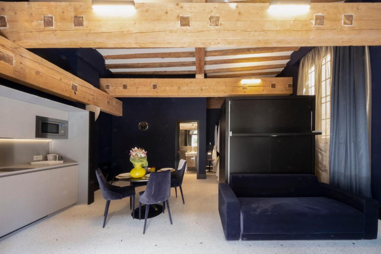 een woonkamer met een tafel en stoelen en een plafond bij Residence Poli Venezia in Venetië