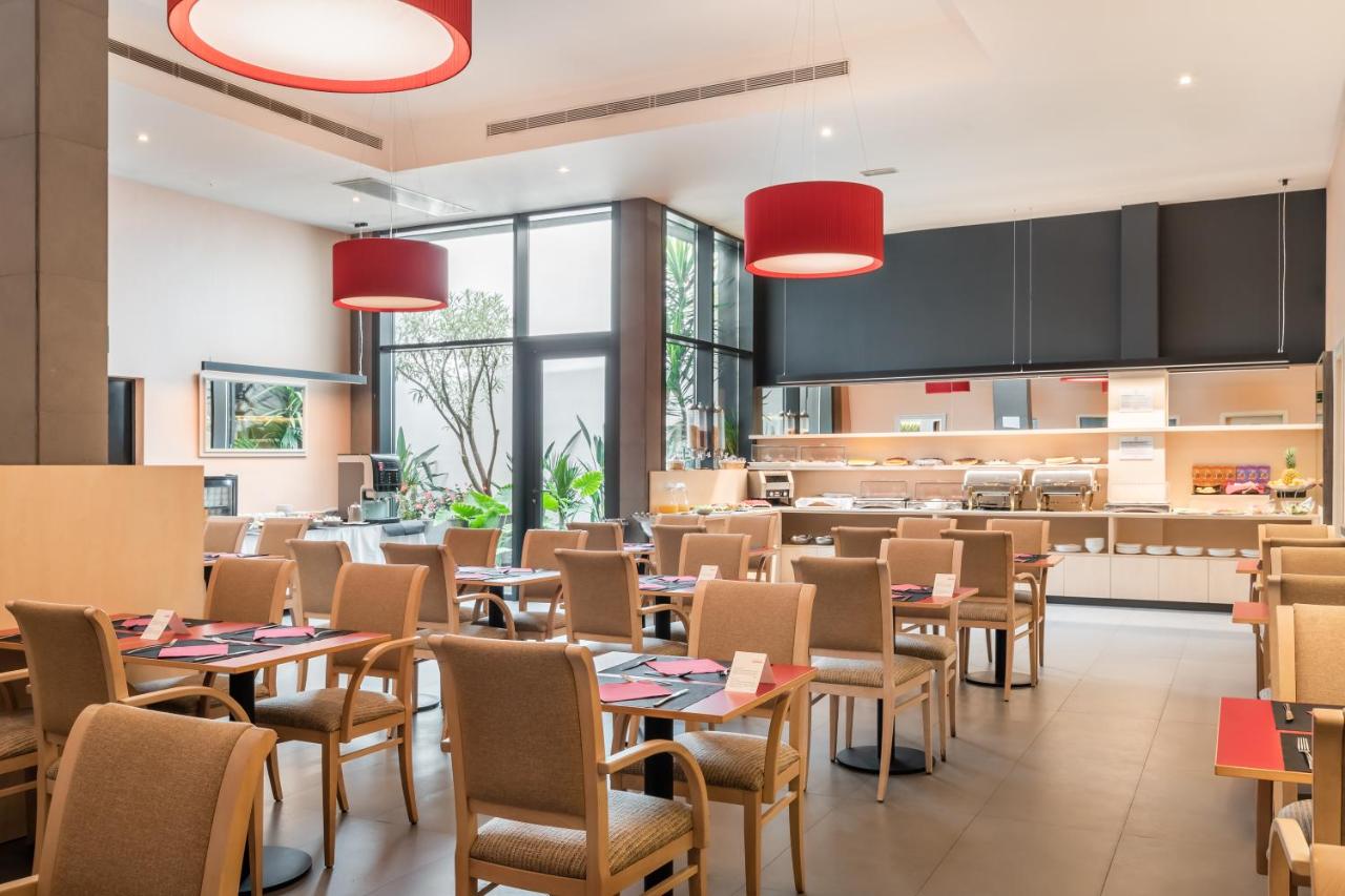 een restaurant met tafels en stoelen en een keuken bij Petit Palace Trencadís in Barcelona +23 foto's