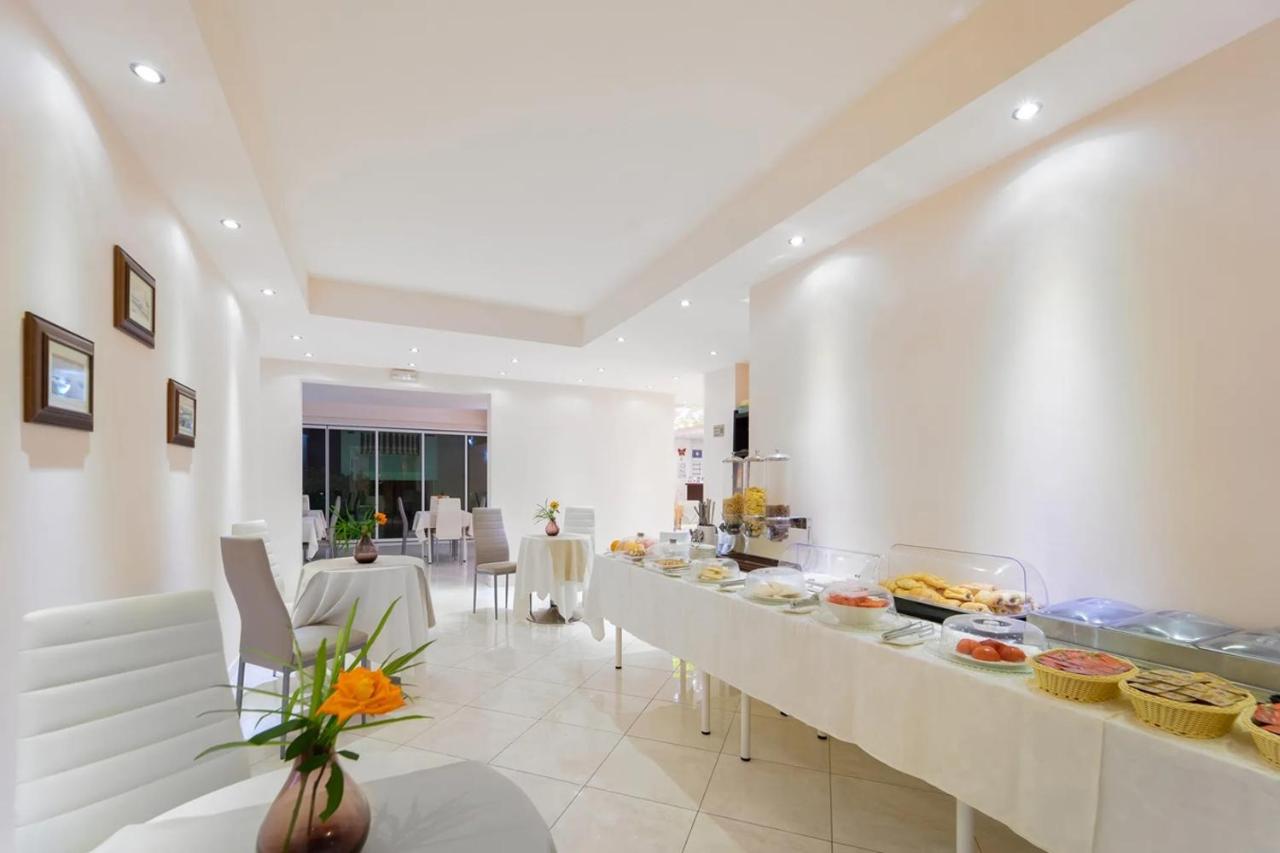 een eetkamer met een lange tafel waarop eten staat bij Golden Rose Suites in Kolymvari